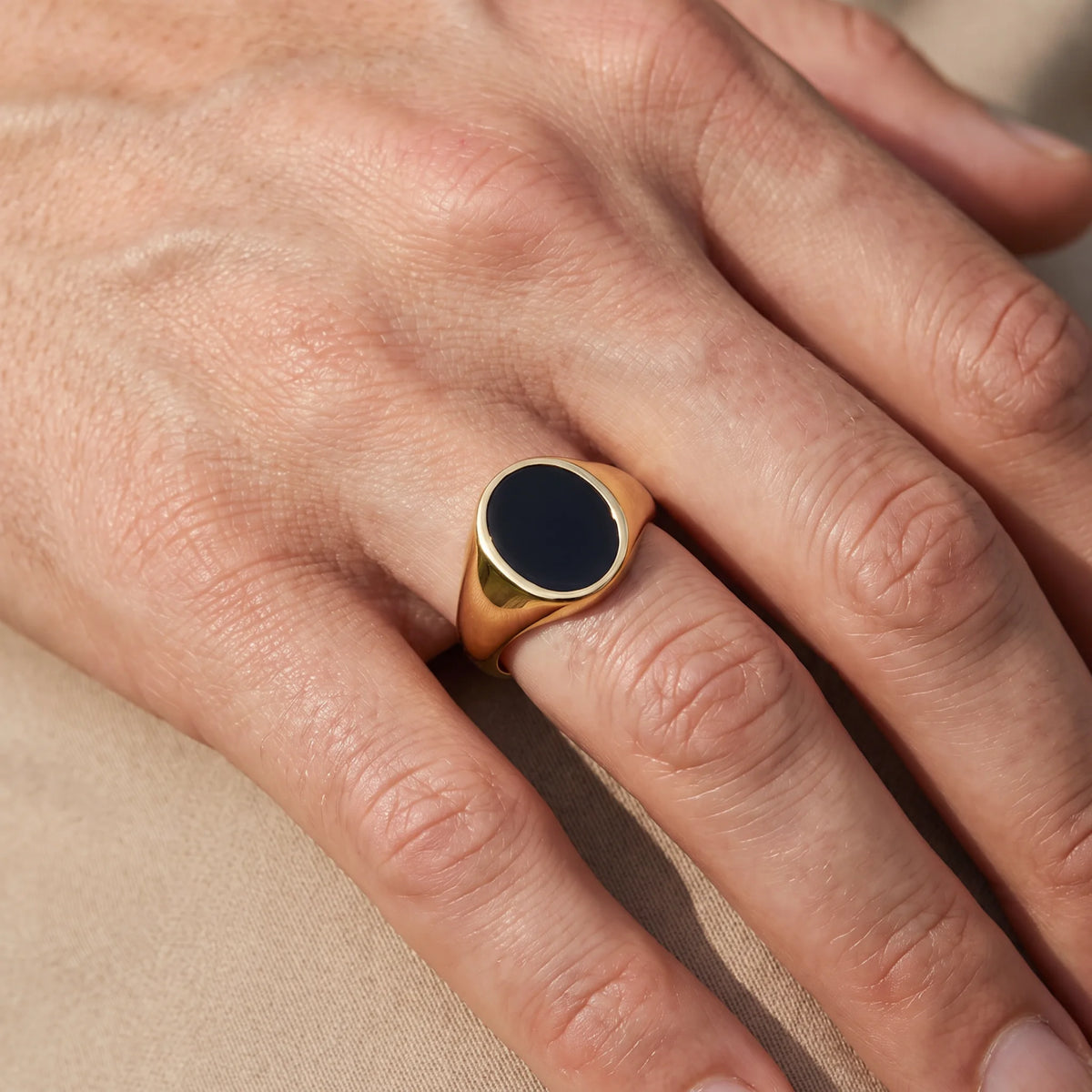 Herrenring in 585er Gelbgold mit Lagenstein oder Onyx, an der Hand getragen (KI-generiert)