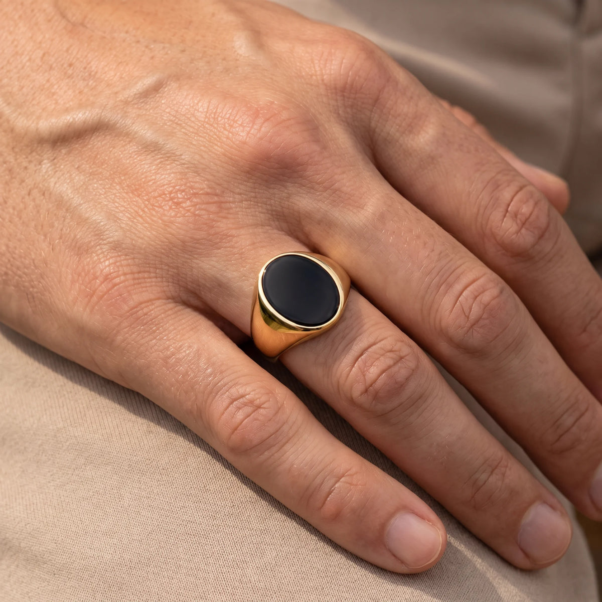 Herrenring in 585er Gelbgold mit Lagenstein oder Onyx, an der Hand getragen (KI-generiert)