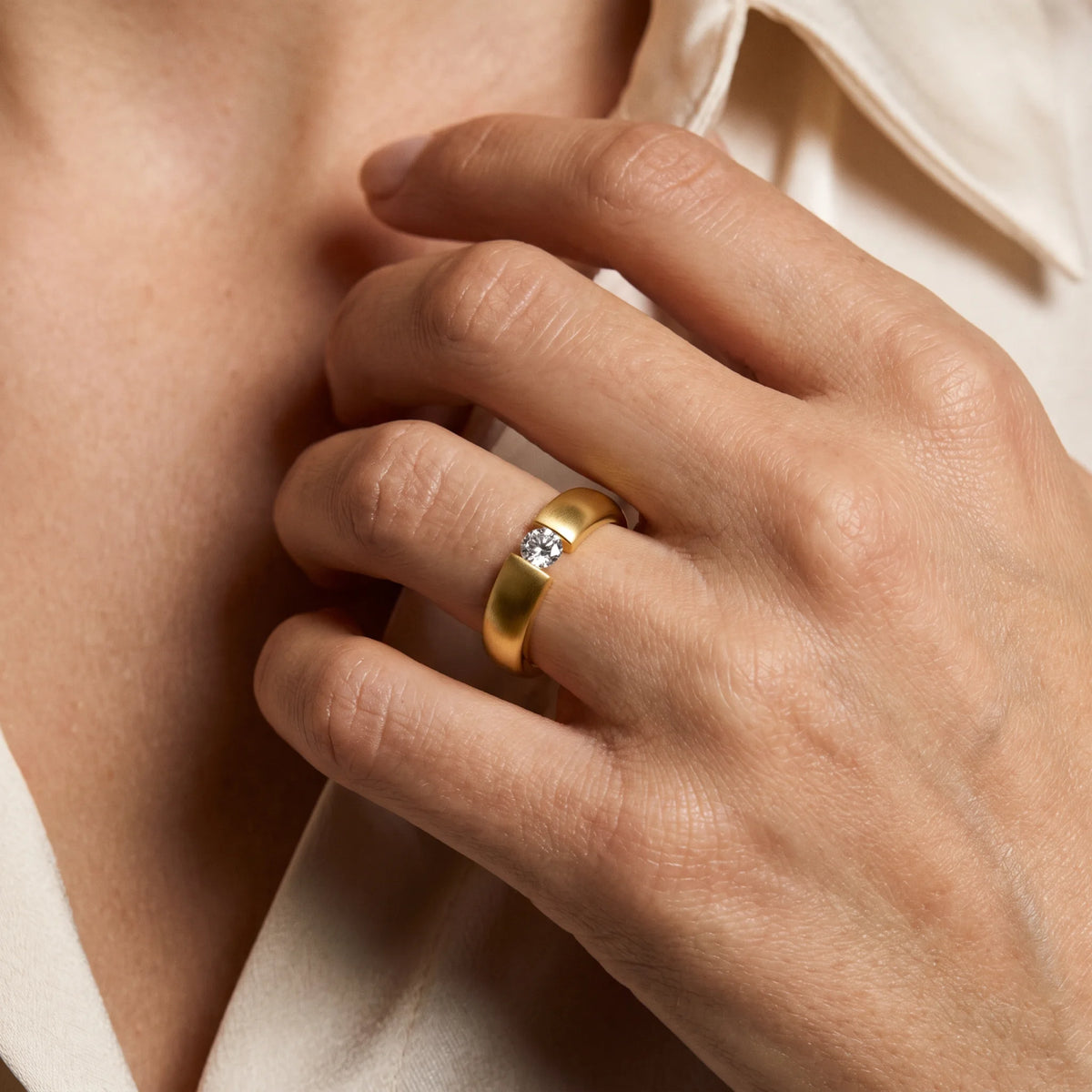 Solitärring in 585er Gold mit Diamant, an der Hand getragen (KI-generiert)
