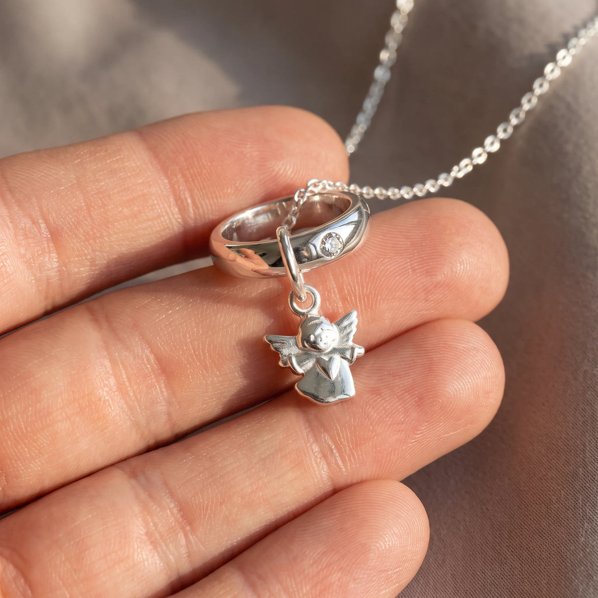 Taufring in 925er Silber mit Zirkonia, an der Kette getragen (KI-generiert)