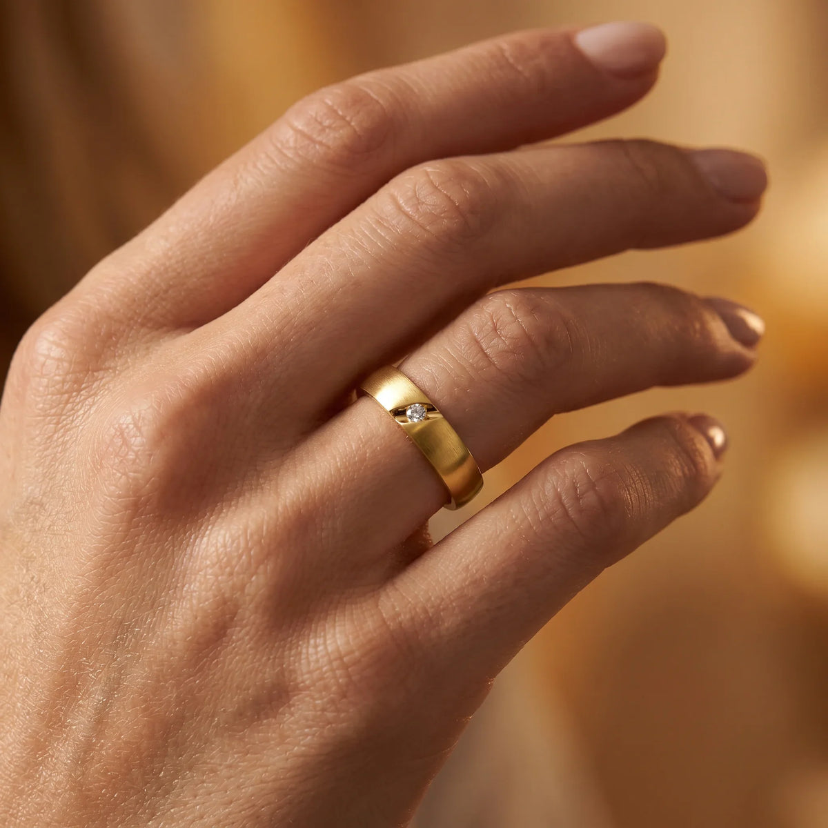 Ring in 585er Gold mit Diamant, an der Hand getragen (KI-generiert)