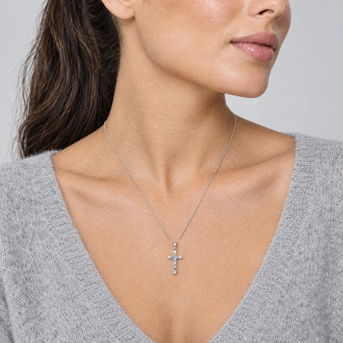 Korpuskreuzanhänger in 925 Silber, getragen an feiner Kette (KI-generiert)