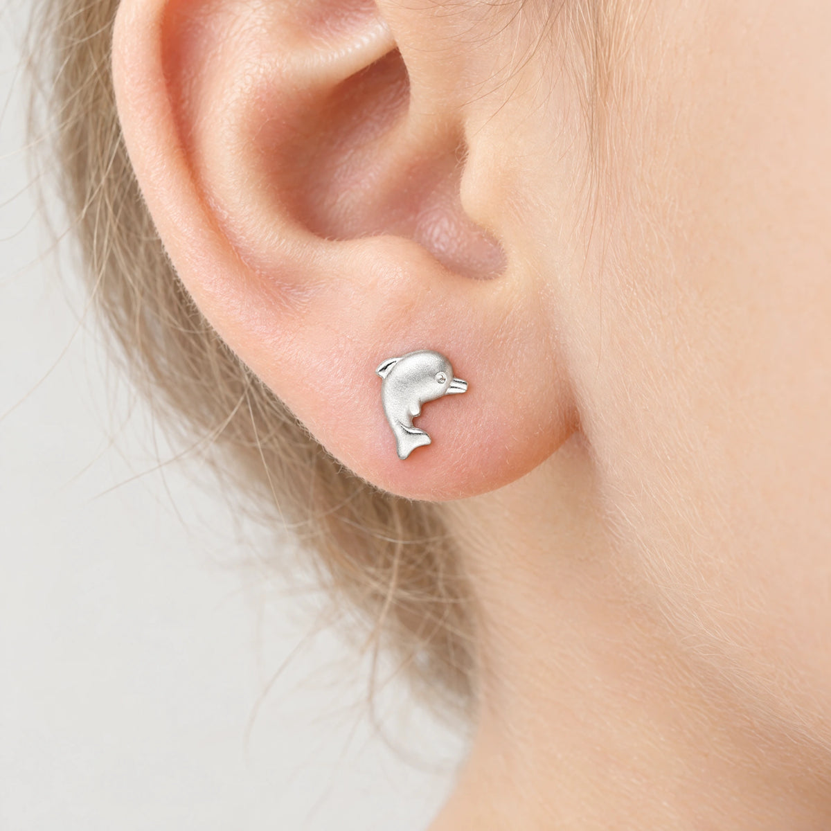 Ohrstecker „Delfin“ in 925er Silber, am Ohr getragen (KI-generiert)