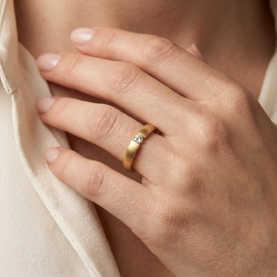 Solitärring in 585er Gold mit Diamant, an der Hand getragen (KI-generiert)
