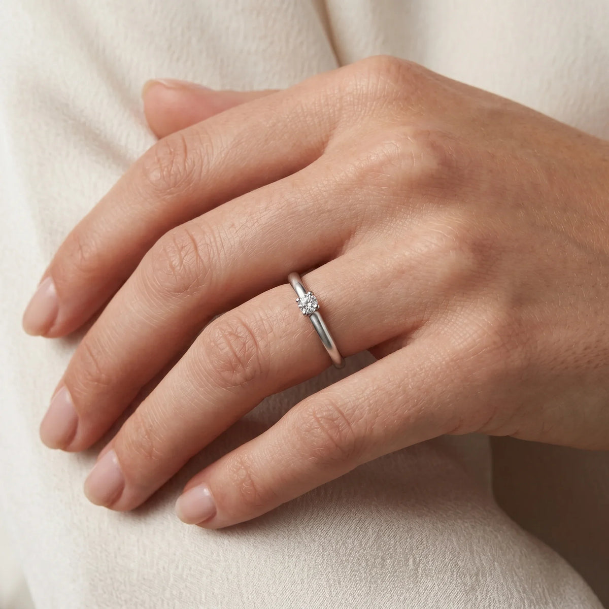 Solitärring in 925er Silber rhodiniert mit Diamant, an der Hand getragen (KI-generiert)