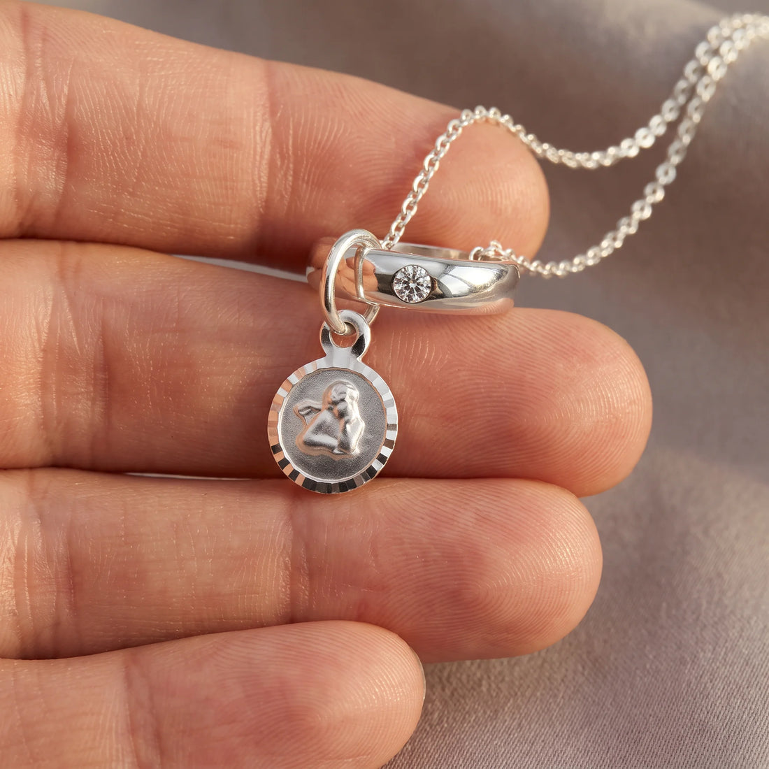 Taufring in 925er Silber mit Zirkonia, an der Kette getragen (KI-generiert)