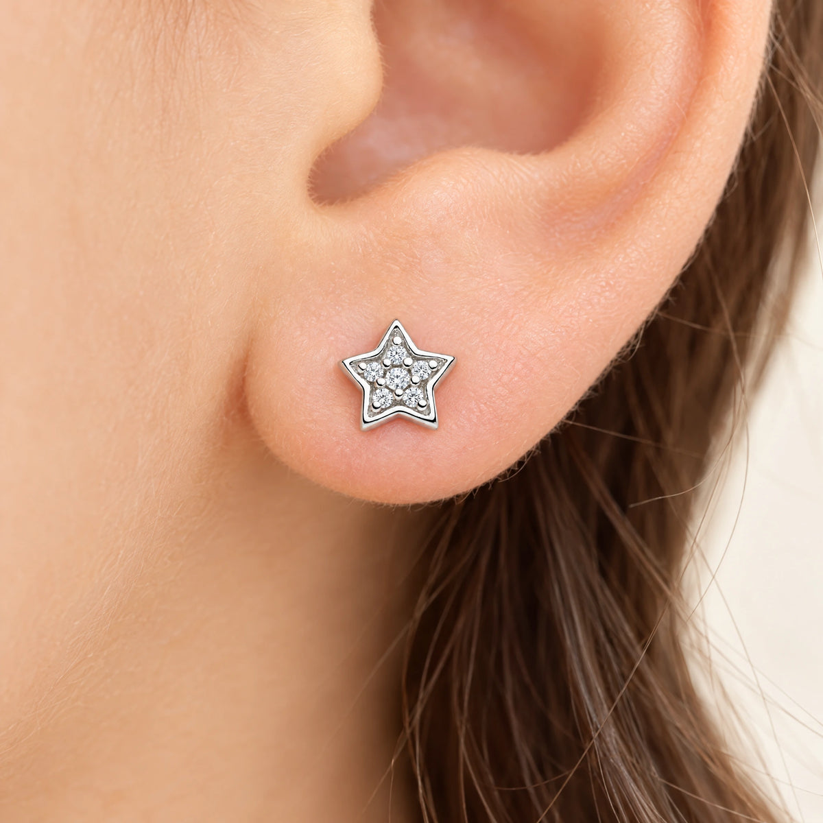 Ohrstecker „Stern“ in 925er Silber rhodiniert mit Zirkonia, am Ohr getragen (KI-generiert)