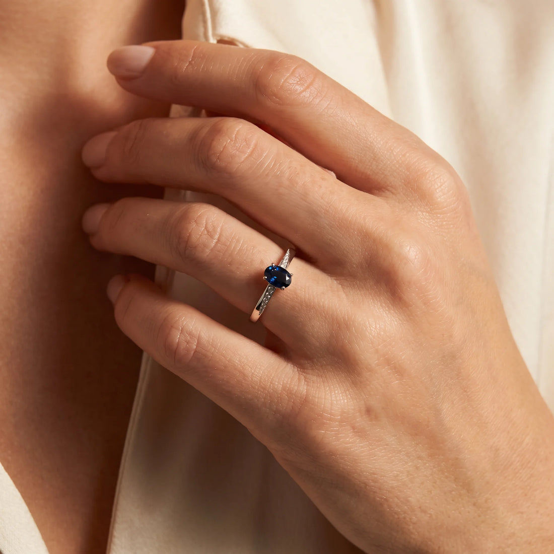 Ring in 585er Weißgold mit Diamant &amp; Saphir, an der Hand getragen (KI-generiert)