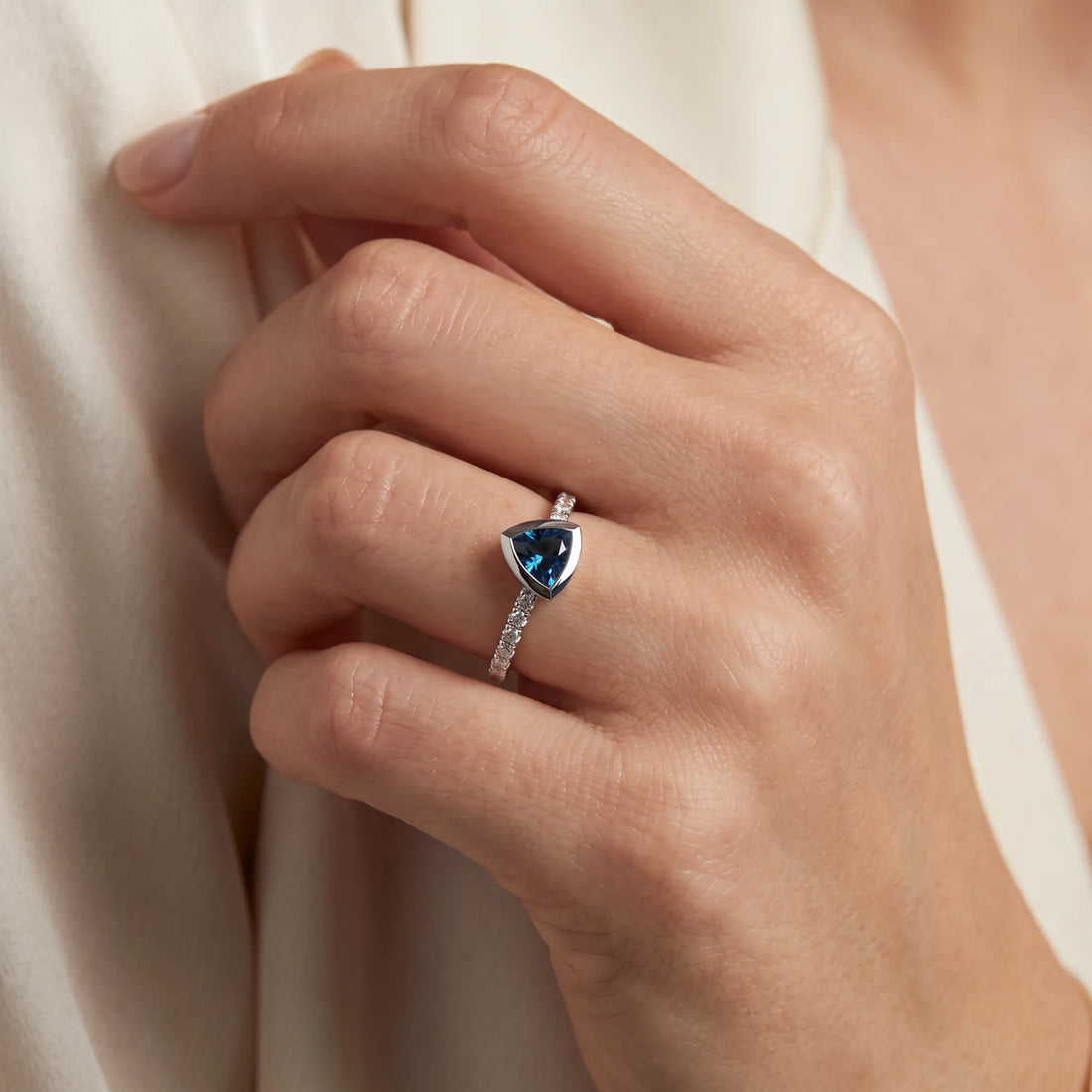 Ring in 585er Weißgold mit Diamant &amp; Blautopas, an der Hand getragen (KI-generiert)