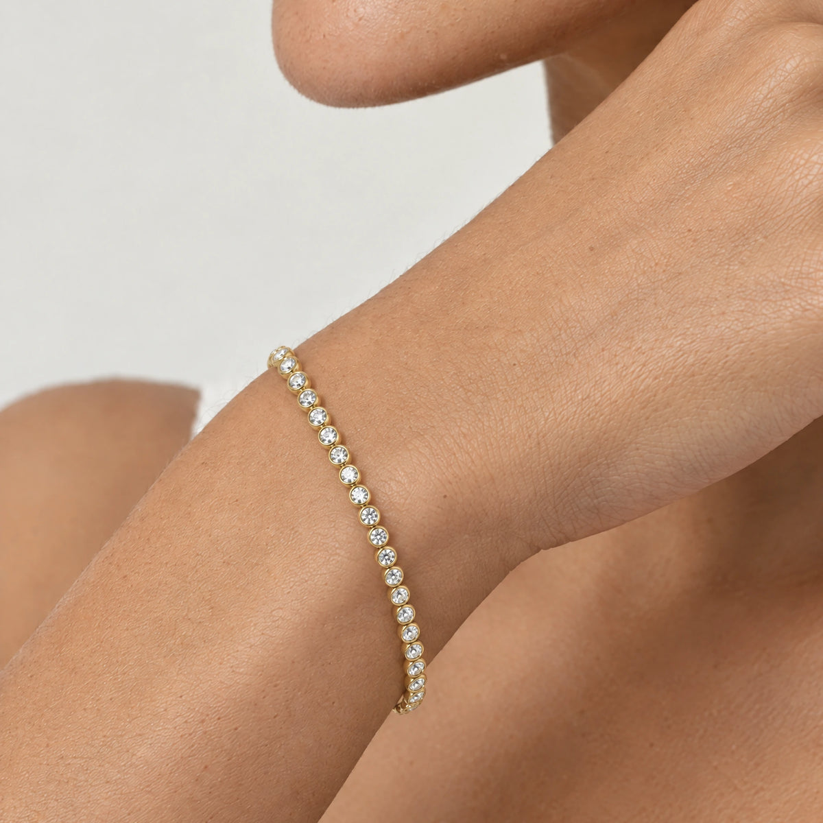 Tennisarmband in Gold am Handgelenk getragen