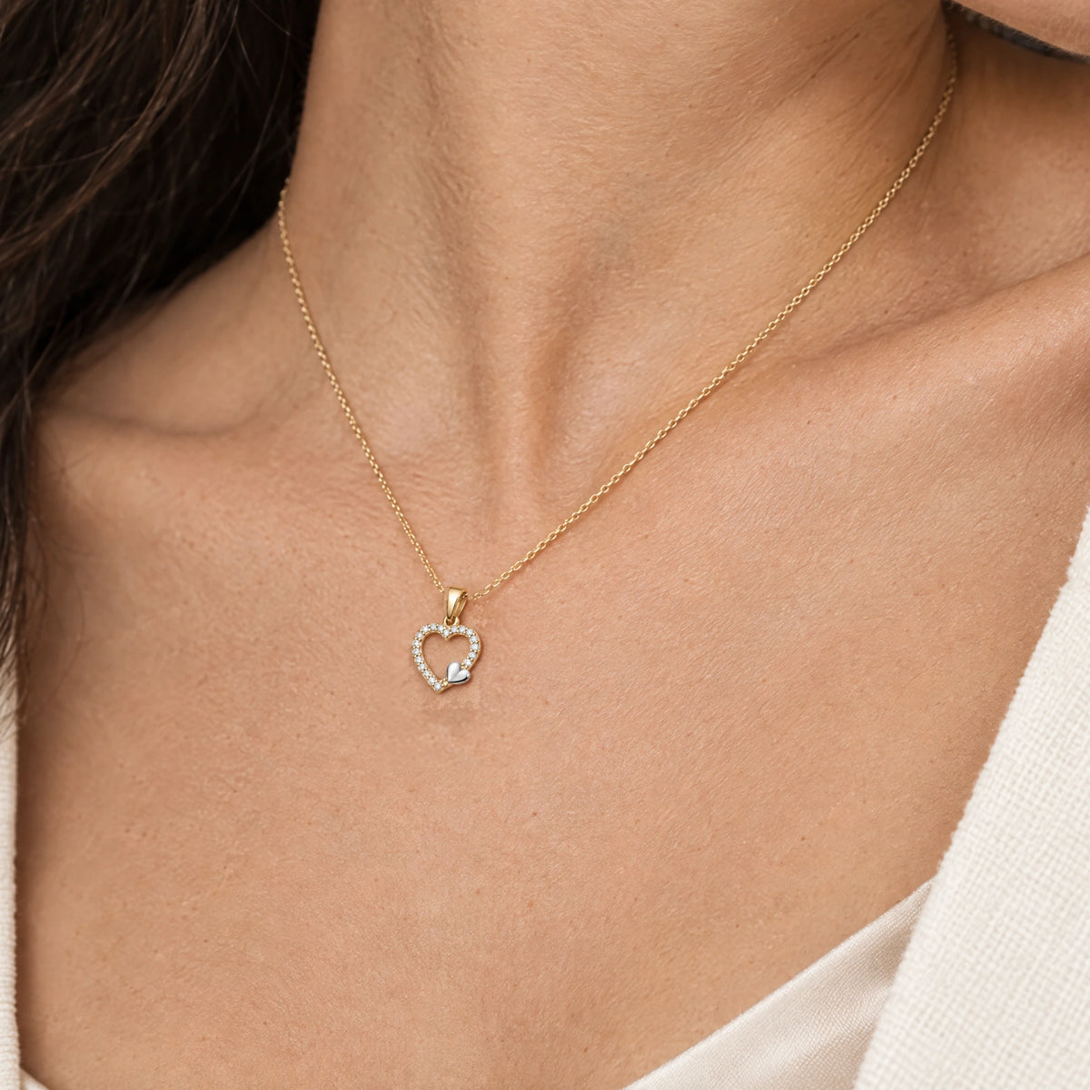 Herzanhänger in Gold mit Zirkonia am Hals getragen